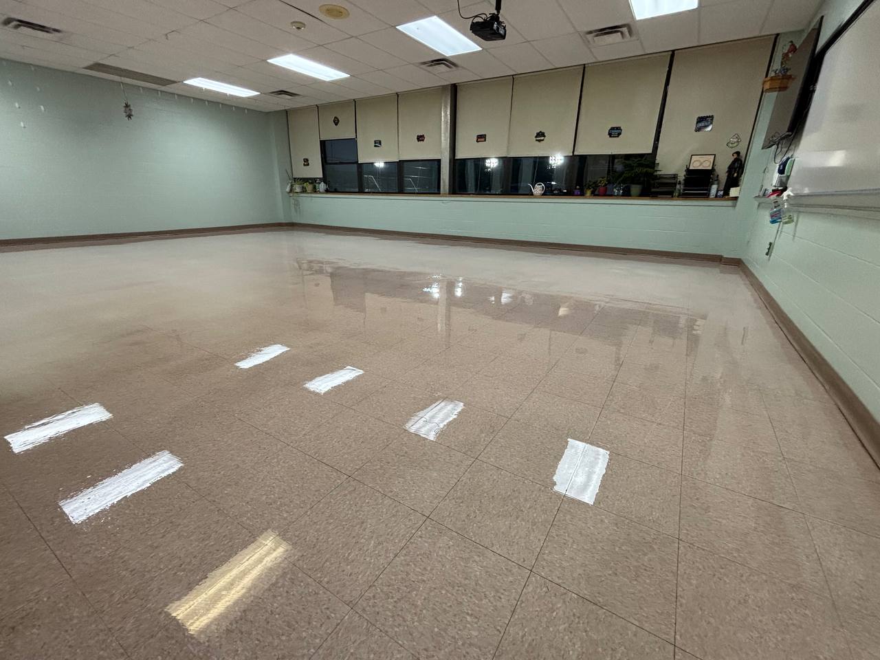Classroom with a reflective hard-floor finish under ceiling lights