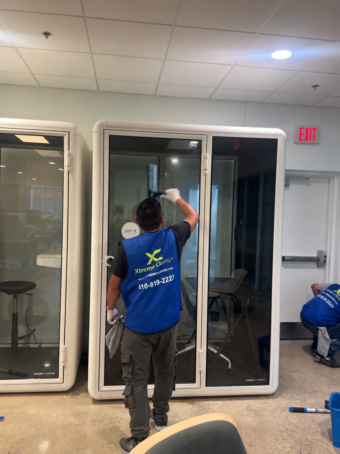 Team member cleaning glass on an office meeting booth